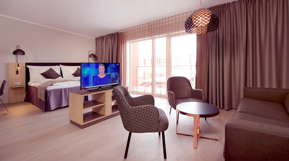 Deluxe dubbelrum med säng, tv, sittgrupp och fönster på Clarion Collection Hotel Hammer 