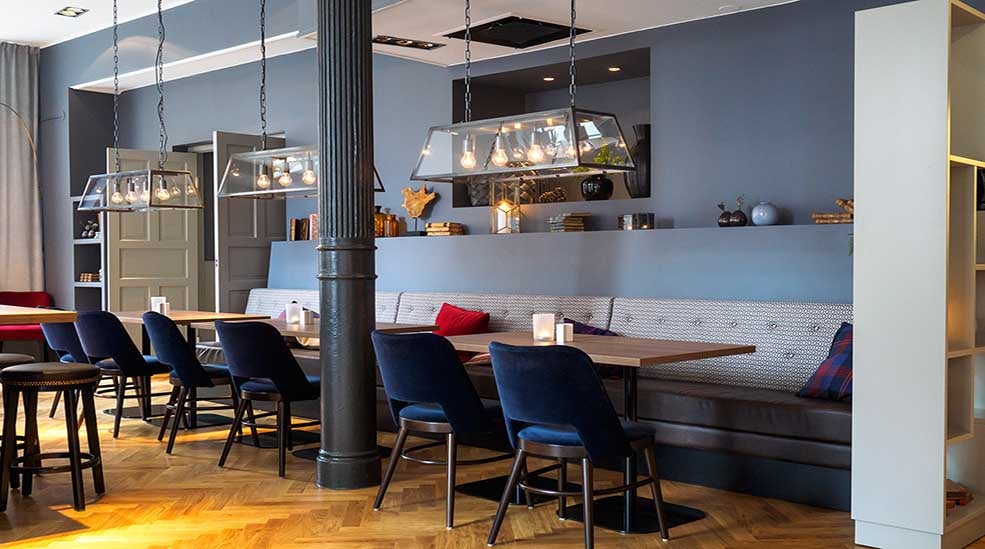 Sittplatser i restaurangen med stolar och soffor Clarion Collection Hotel Temperance i Malmo