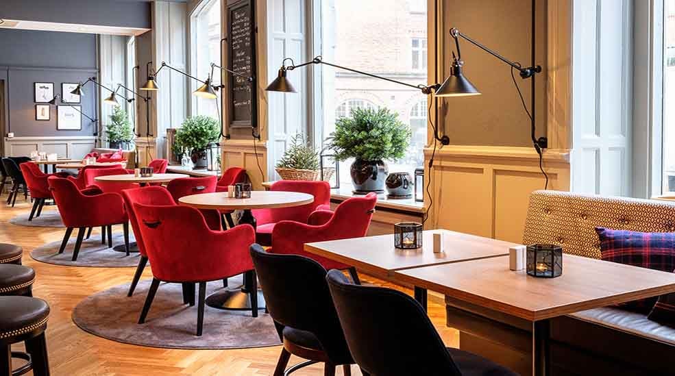 Sittplatser i restaurangen med fåtöljer och fina lampor på Clarion Collection Hotel Temperance i Malmo